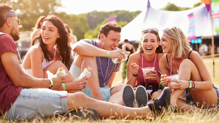 Friends laughing together at an outdoor music festival