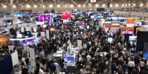 Aerial view of a busy trade show floor with exhibitor booths and attendees