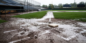 Rain flooding an empty youth sports field during a game rainout
