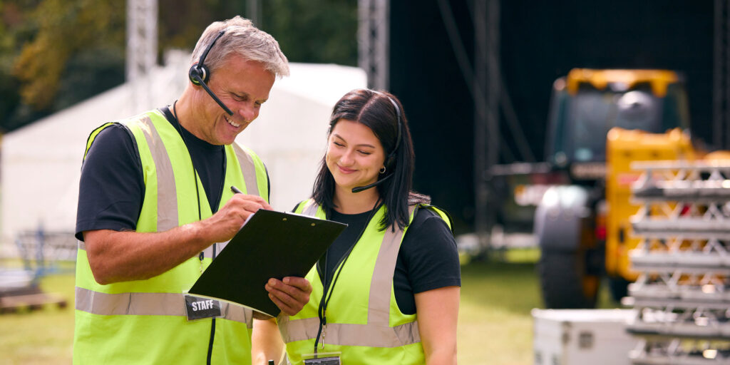 Festival staff in vests coordinating logistics on the festival grounds